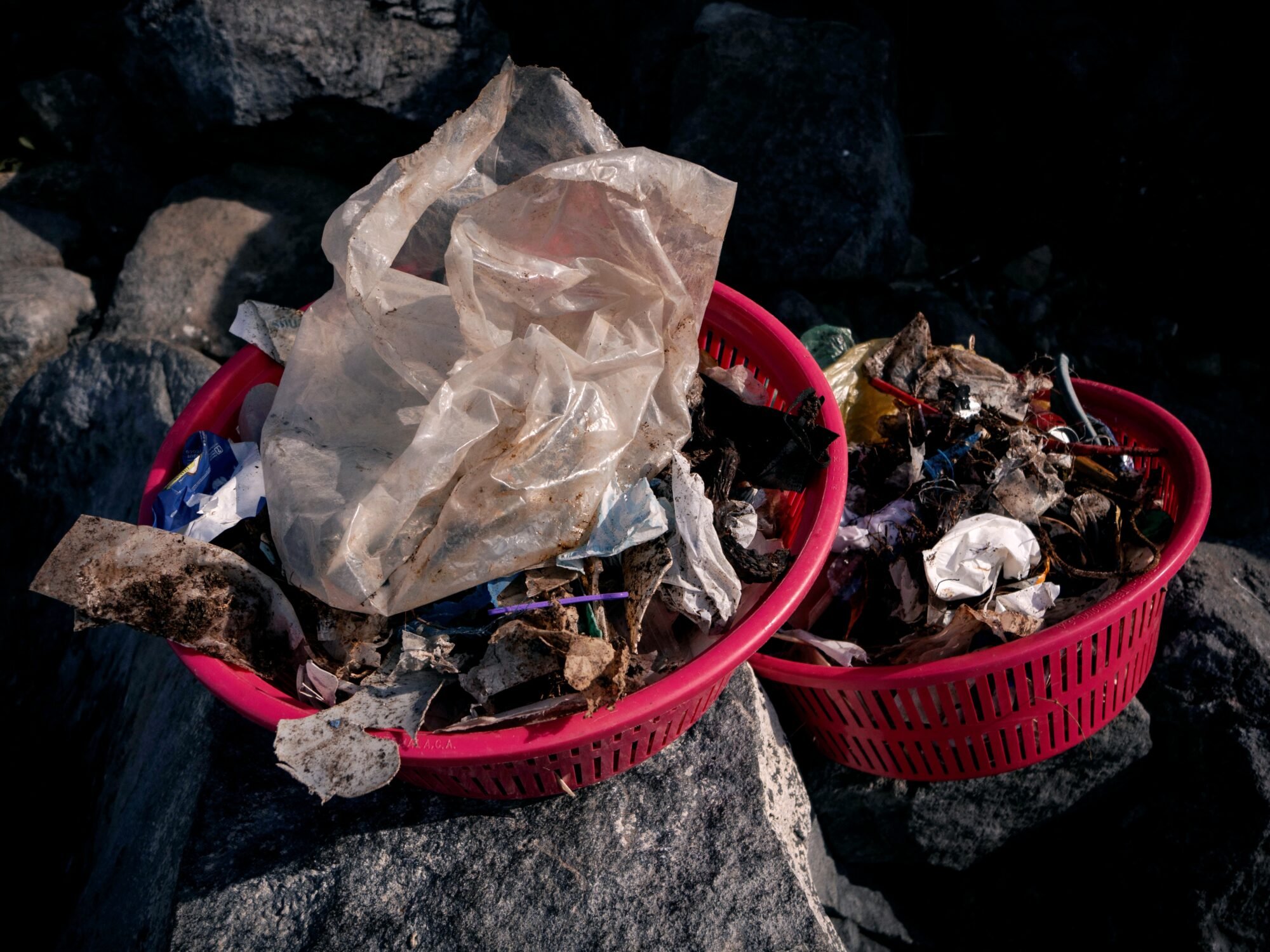  Dos mujeres cargan sus costales mientras recogen las basuras en la orilla del lago Atitlán en San Pedro La Laguna. Foto de Alex PV 