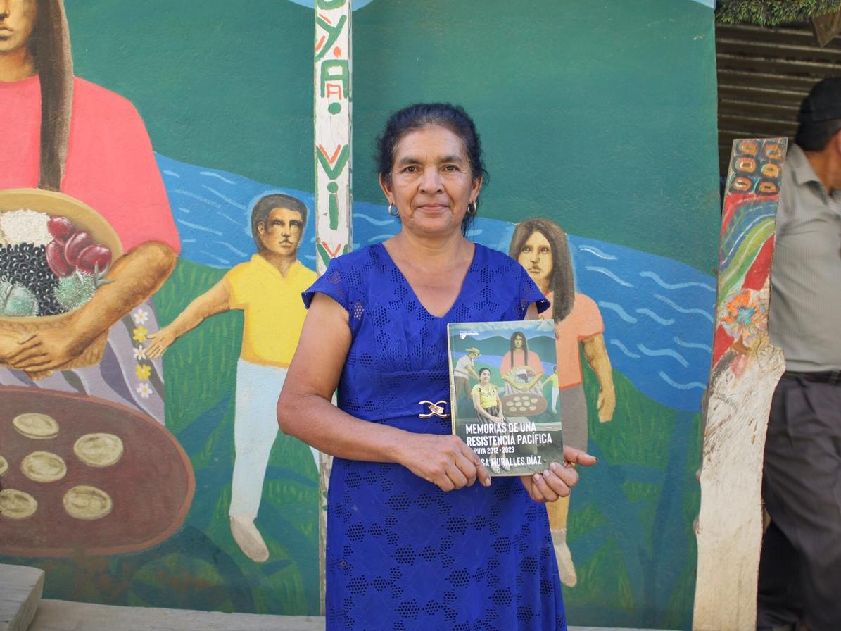 Créditos: Felisa Muralles sostiene con orgullo su libro en el plantón de la resistencia de La Puya. Foto de Derik Mazariegos