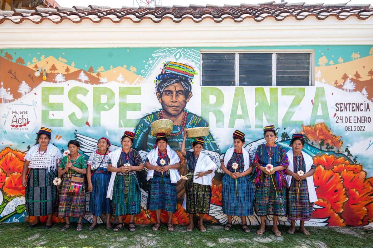 Créditos: Mujeres Achi frente al mural elaborado como parte de las medidas de reparación en el juicio de 2023. Foto Impunity Watch Guatemala
