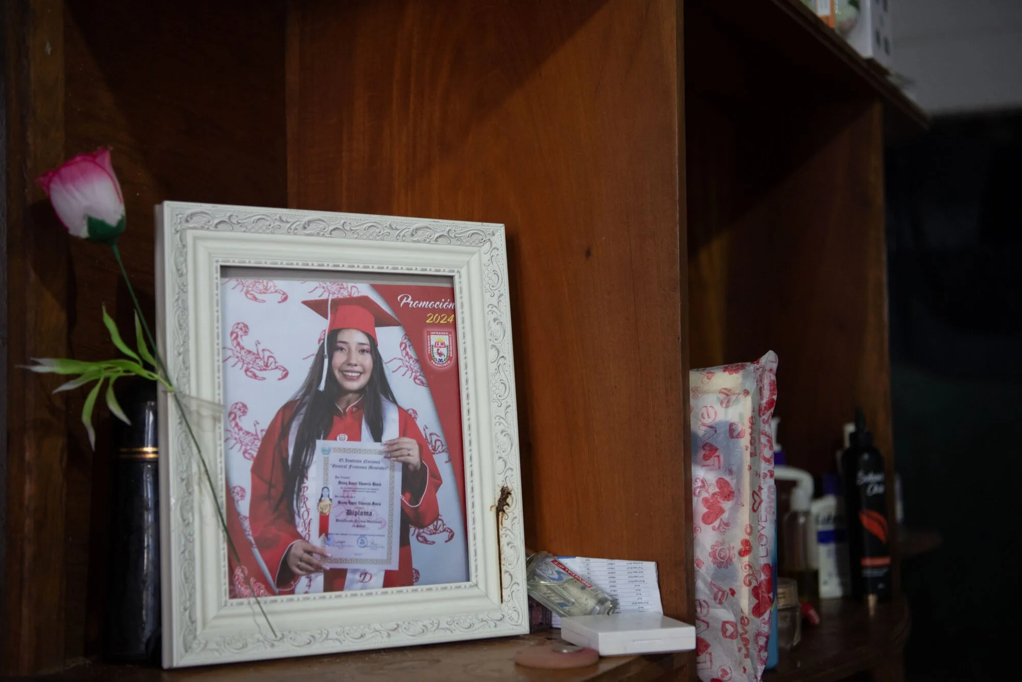  Una fotografía de graduación de Melany aparece en su lugar de habitación. Foto de Prensa Comunitaria 