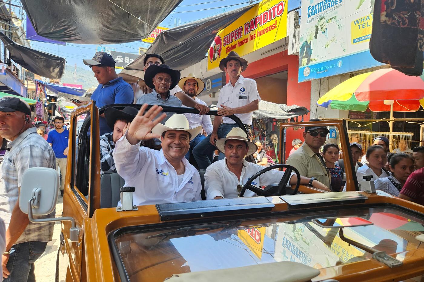  Carlos Pineda (izquierda), candidato a la Presidencia por el partido Prosperidad Ciudadana, recorre las principales calles de un municipio del occidente de Guatemala. Al fondo, en un vehículo se observa a Mechito, un influencer de redes sociales que utilizó el candidato para captar el voto popular. Sin embargo, días antes de la primera vuelta electoral quedó excluido del proceso. Municipio de Santa Cruz Barillas, Huehuetenango, 3 de mayo de 2023. Foto de Francisco Simón 