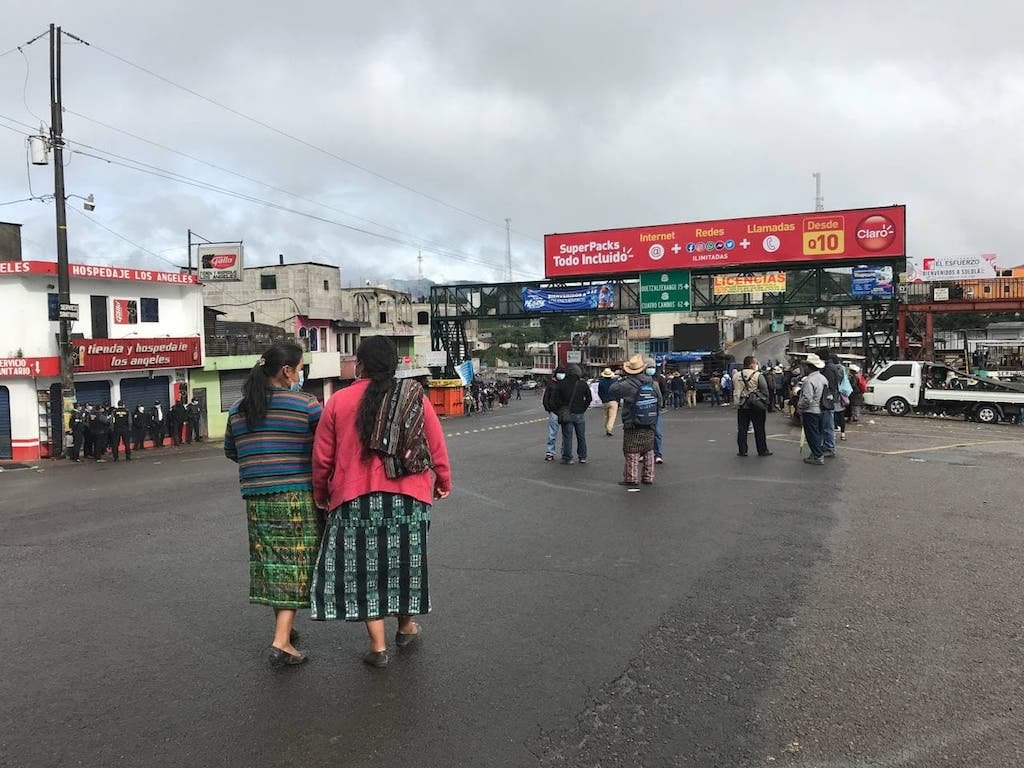  Dos mujeres se apuran para escuchar el mensaje de las autoridades indígenas en Los Encuentros. Foto: Paolina Albani. 
