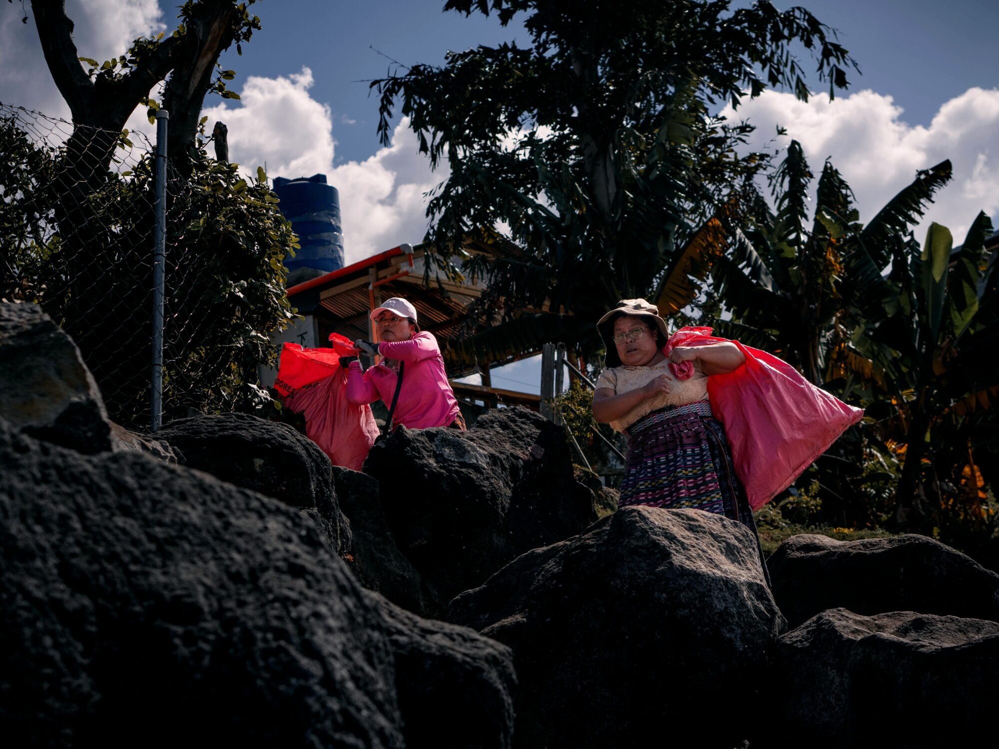  Dos mujeres cargan sus costales mientras recogen las basuras en la orilla del lago Atitlán en San Pedro La Laguna. Foto de Alex PV 