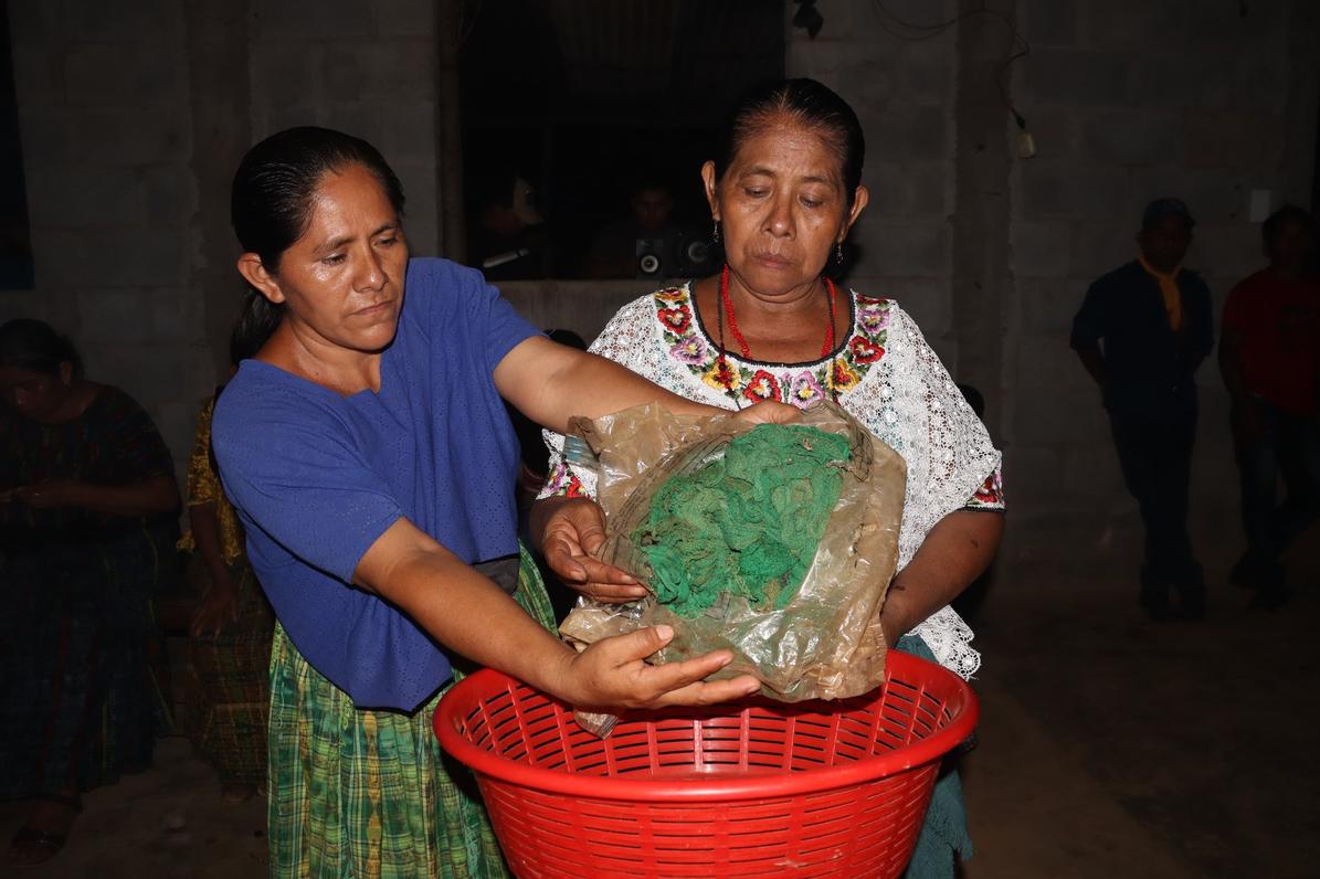María Maquín ofrenda el perraje de su abuela Adelina Caal en el altar ceremonial. Foto Juan Bautista Xol