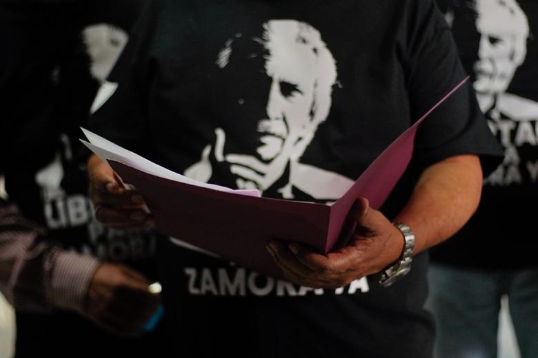 Una mujer sosteniendo una pancarta con el rostro de José Rubén Zamora